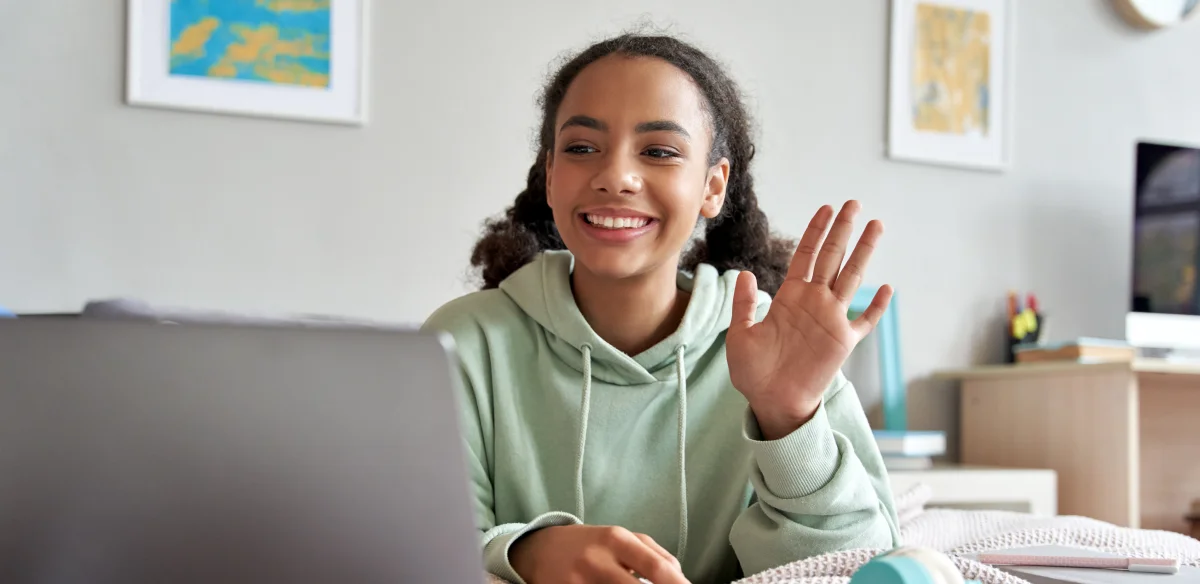 High school student waiving at her online class